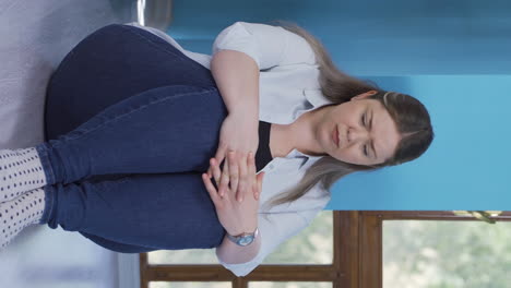 Vertical-video-of-Depressed-woman.-It-sits-by-the-wall.